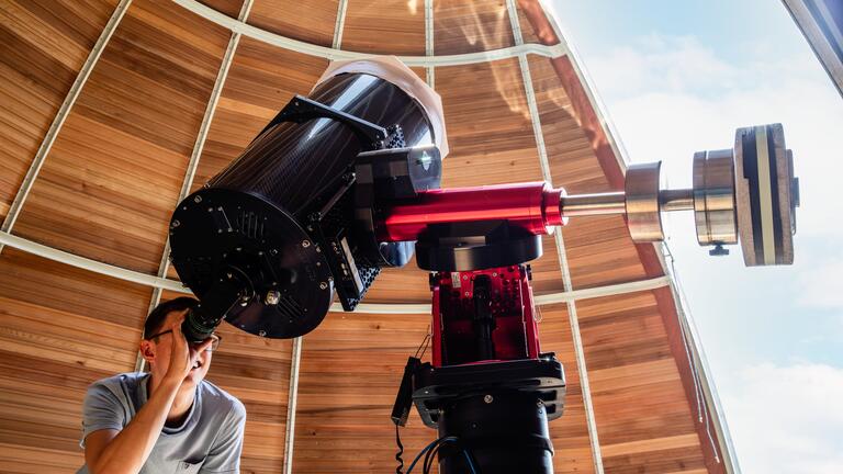 Student using telescope at observatory
